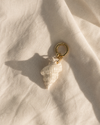Charm ceramico con cierre dorado de acero inoxidable sobre lino