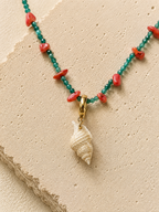 Charm ceramico con cierre dorado de acero inoxidable sobre piedra caliza